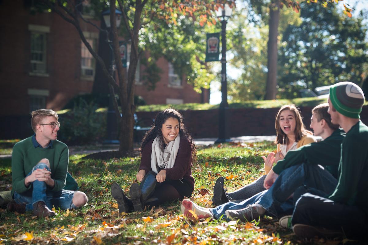 学生们坐在大学绿地上聊天